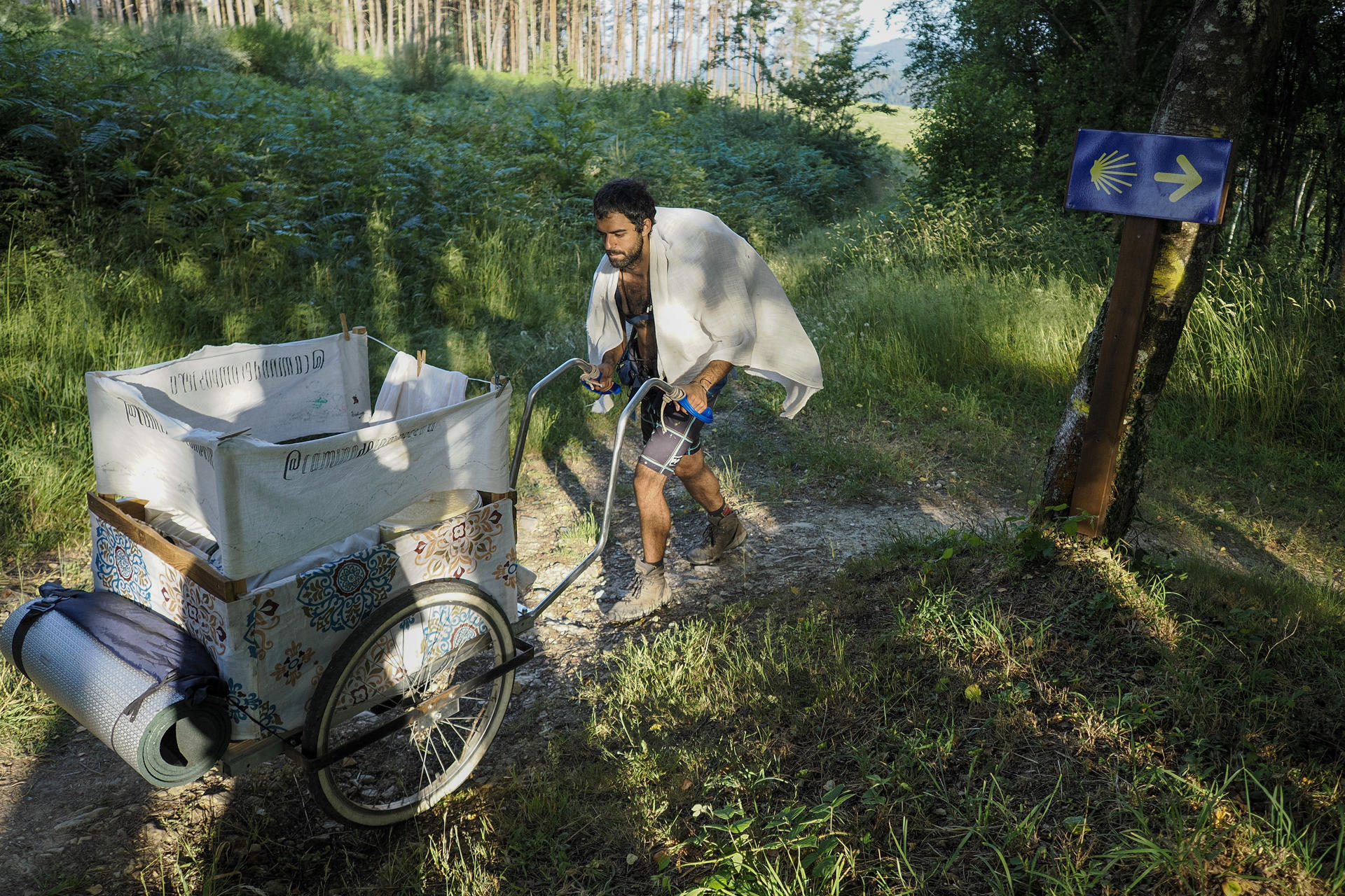 El artista Alberto Monreal a su paso por A Fonsagrada, Lugo, durante el 'Camino de compostera', su último proyecto en el que recorre a pie los 900 kilómetros que hay entre Santiago y Zaragoza cargando con todos los residuos que genera el viaje para reflexionar sobre la basura, la naturaleza y el arte. EFE/ Eliseo Trigo
