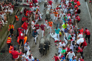 Varios mozos son perseguidos por los toros de la ganadería de José Escolar en el tramo del Callejón durante el sexto encierro de los Sanfermines, este sábado en Pamplona. EFE/ Ainhoa Tejerina