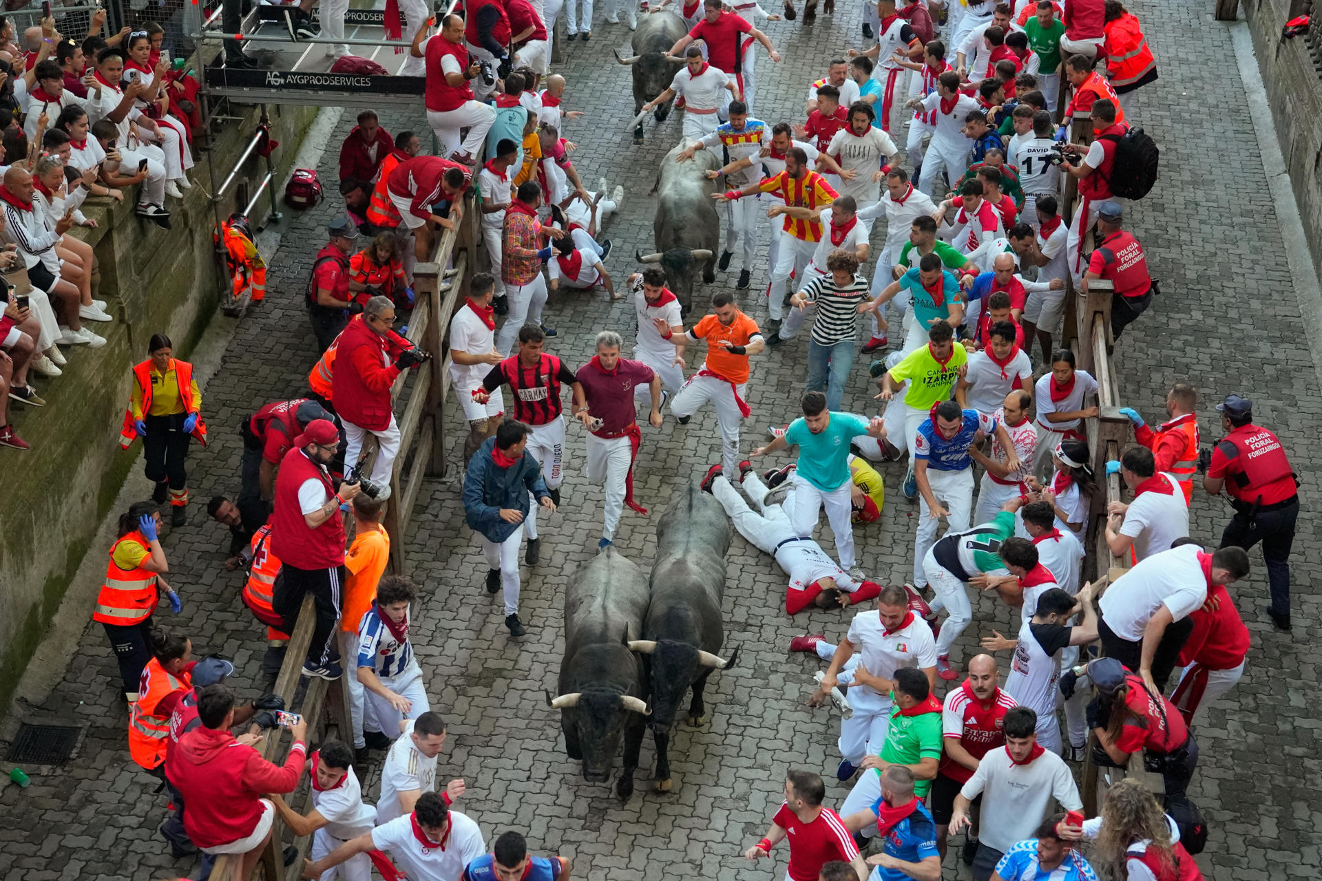 Varios mozos son perseguidos por los toros de la ganadería de José Escolar en el tramo del Callejón durante el sexto encierro de los Sanfermines, este sábado en Pamplona. EFE/ Ainhoa Tejerina