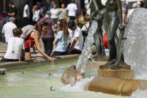 Una mujer se refresca en una fuente del centro de Valencia este jueves. EFE/Biel Aliño