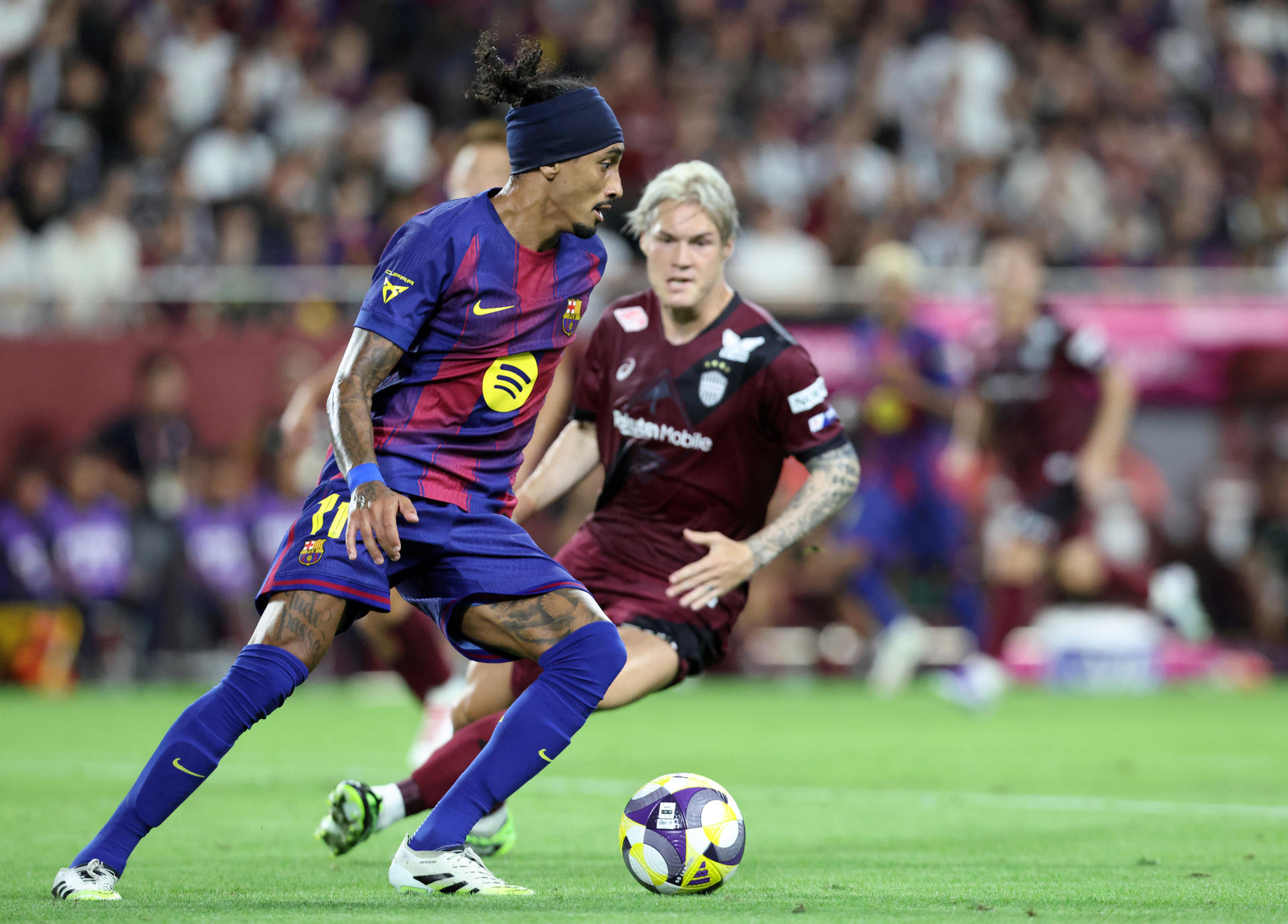 El delantero brasileño del Barcelona Raphinha (i) en acción durante el amistoso entre el Vissel Kobe y el FC Barcelona, en el Noevir Stadium Kobe (Japón). EFE/ Buddhika Weerasinghe