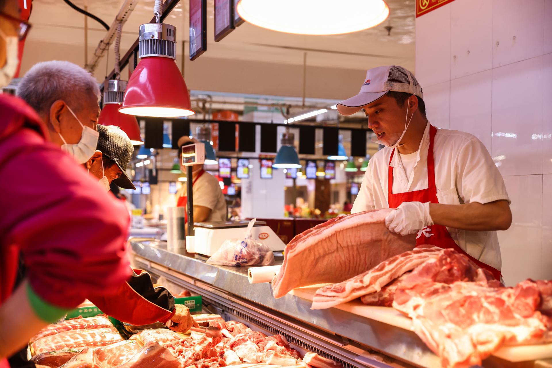 Un empleado trabaja en un puesto de venta de cerdo, en una fotografía de archivo. EFE/WU HAO
