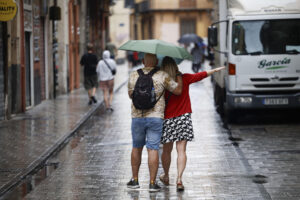 Turistas observan este miércoles la llegada de nubes de lluvia desde la Fortaleza de Isabel II en La Mola, Menorca. EFE/ David Arquimbau Sintes