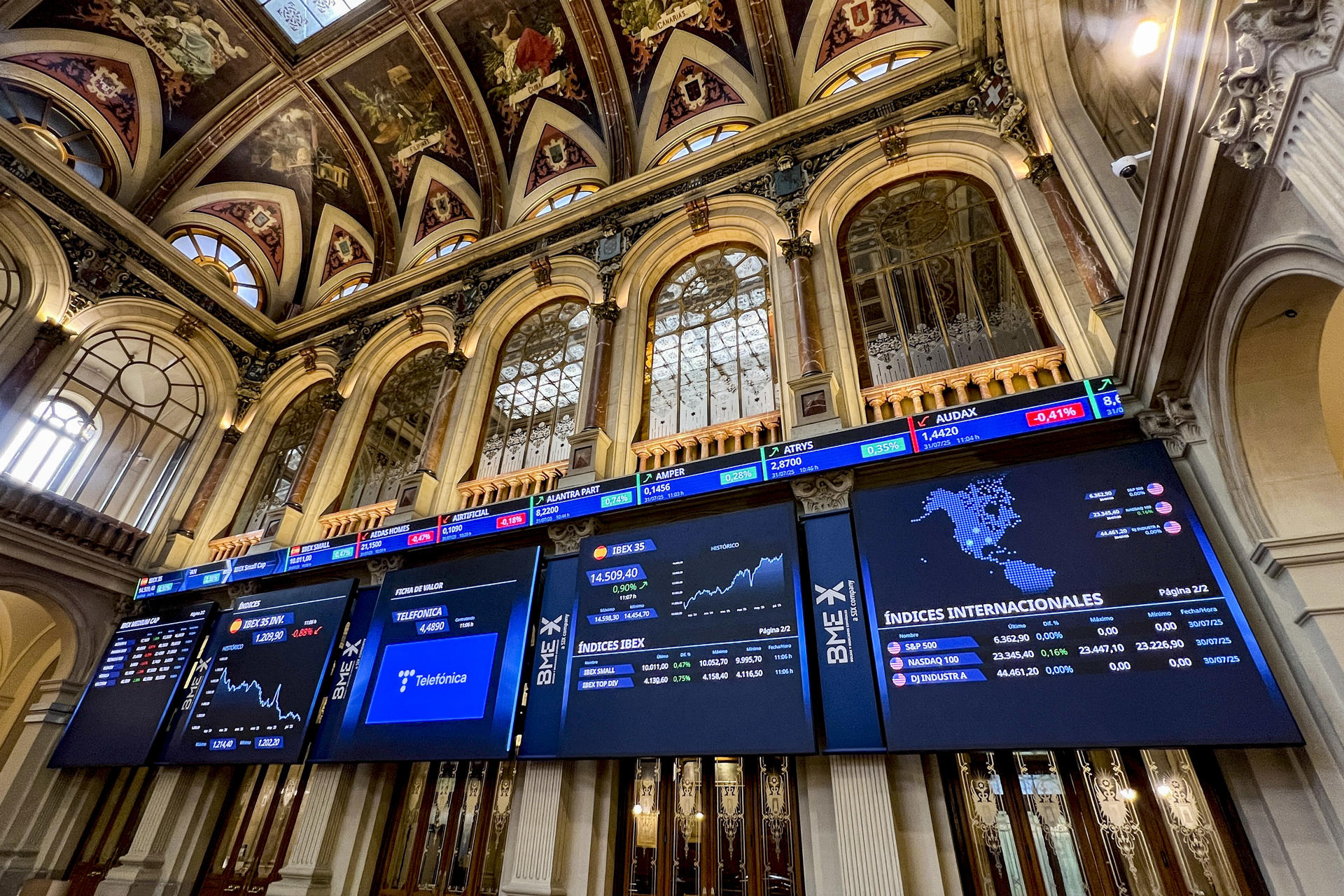 Pantallas de la Bolsa española este jueves que cierra al alza del 0,11 % y se queda a las puertas de los 14.400 puntos, hasta situarse en los 14.397 enteros. EFE/ Altea Tejido