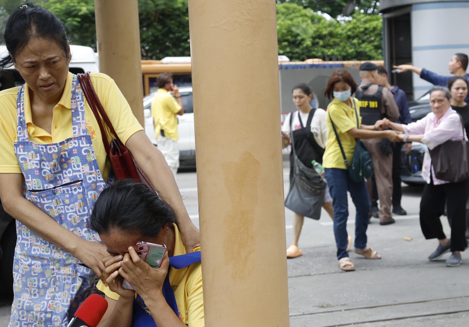 Un grupo de tailandeses en la zona donde se registró un tiroteo este lunes en Bangkok.
EFE/EPA/NARONG SANGNAK
