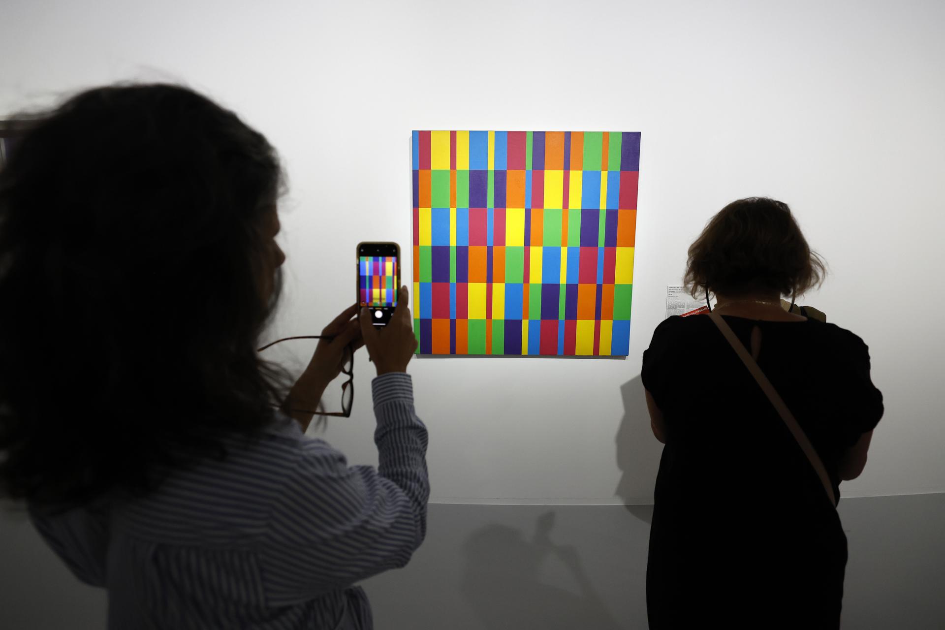 Una persona toma fotografías de la obra ´Sechs horizontale Baender mit je sechs formal gleichen Farbgruppen" (1959-1969) del artista suizo Richard-Paul Lohse, exhibida en la exposición ´¡Colores! Obras maestras del Centro Pompidou´ durante una vista previa en el Foro Grimaldi en Mónaco, el 4 de julio de 2025 (publicada el 7 de julio de 2025). EFE/EPA/Sebastien Nogier