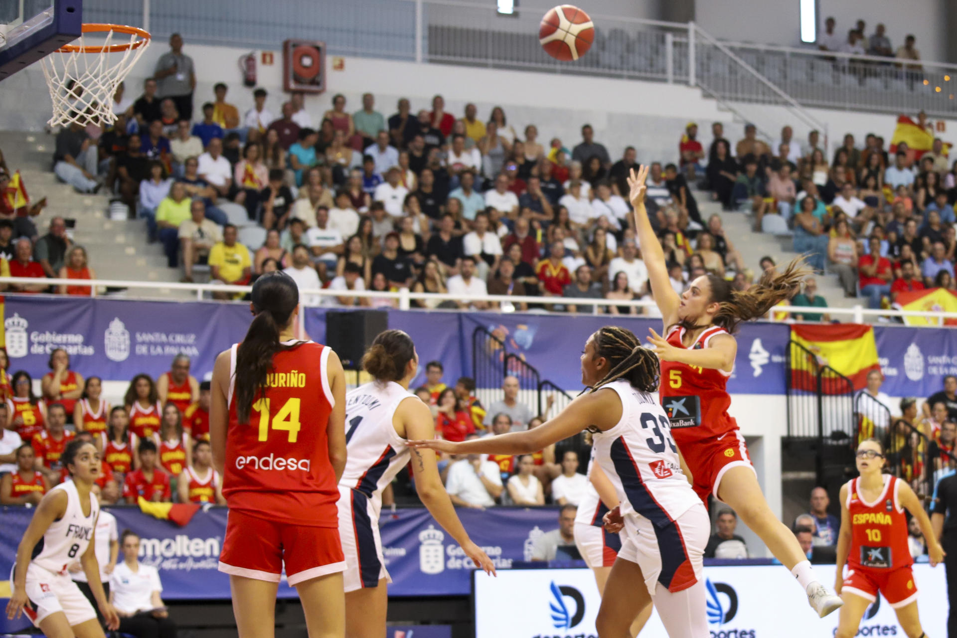 La jugadora de la selección española, Aina Cargol (d), lanza a canasta ante la jugadora de Francia durante el encuentro correspondiente a la semifinal de la Eurocopa Sub 18 que han disputado España y Francia en Santa Cruz de la Palma. EFE/ Luis G Morera
