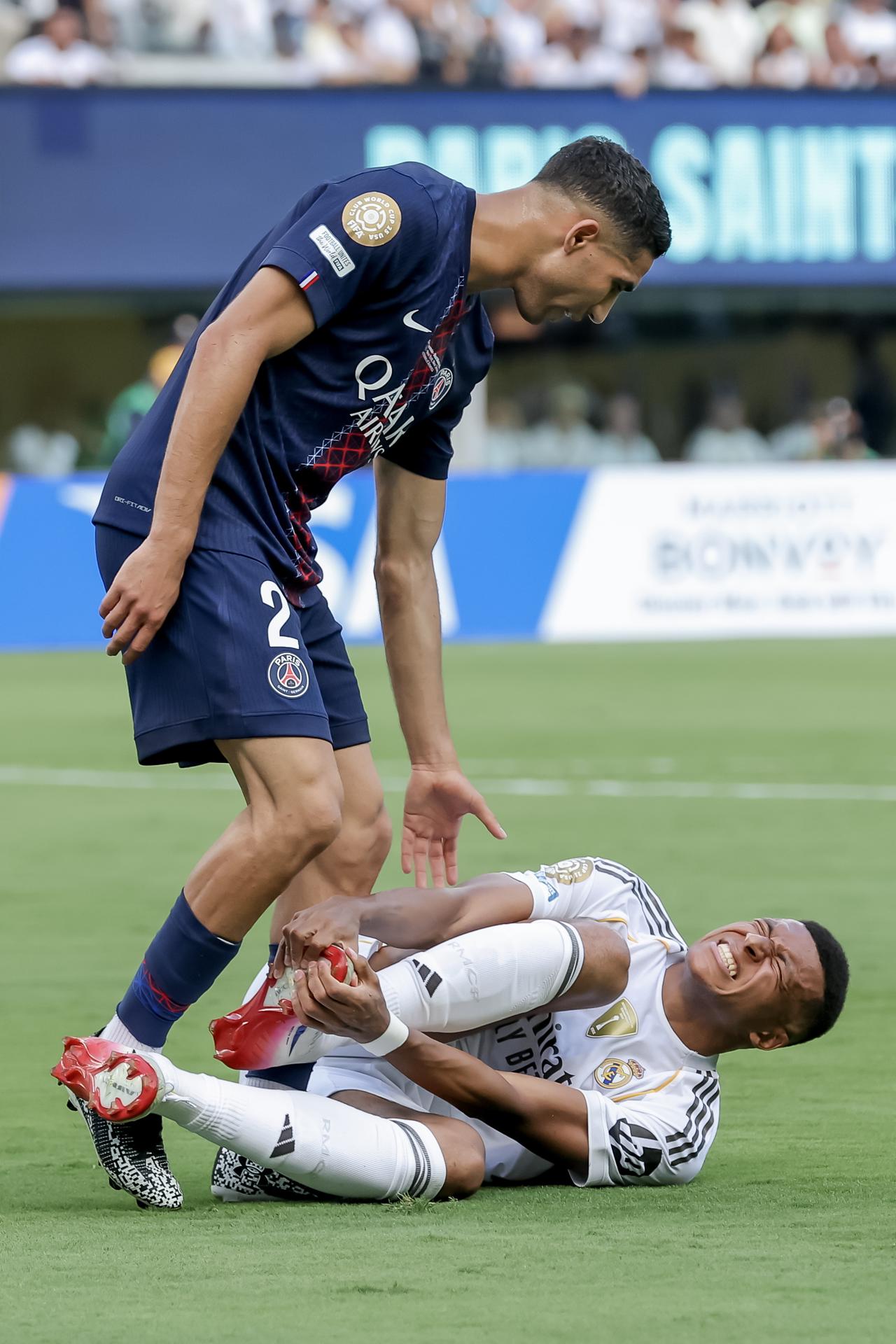 Kylian Mbappe (d) del Real Madrid se lamenta tras un golpe de Achraf Hakimi (i) del PSG durante la semifinal del Mundial de Clubes. EFE/JUSTIN LANE