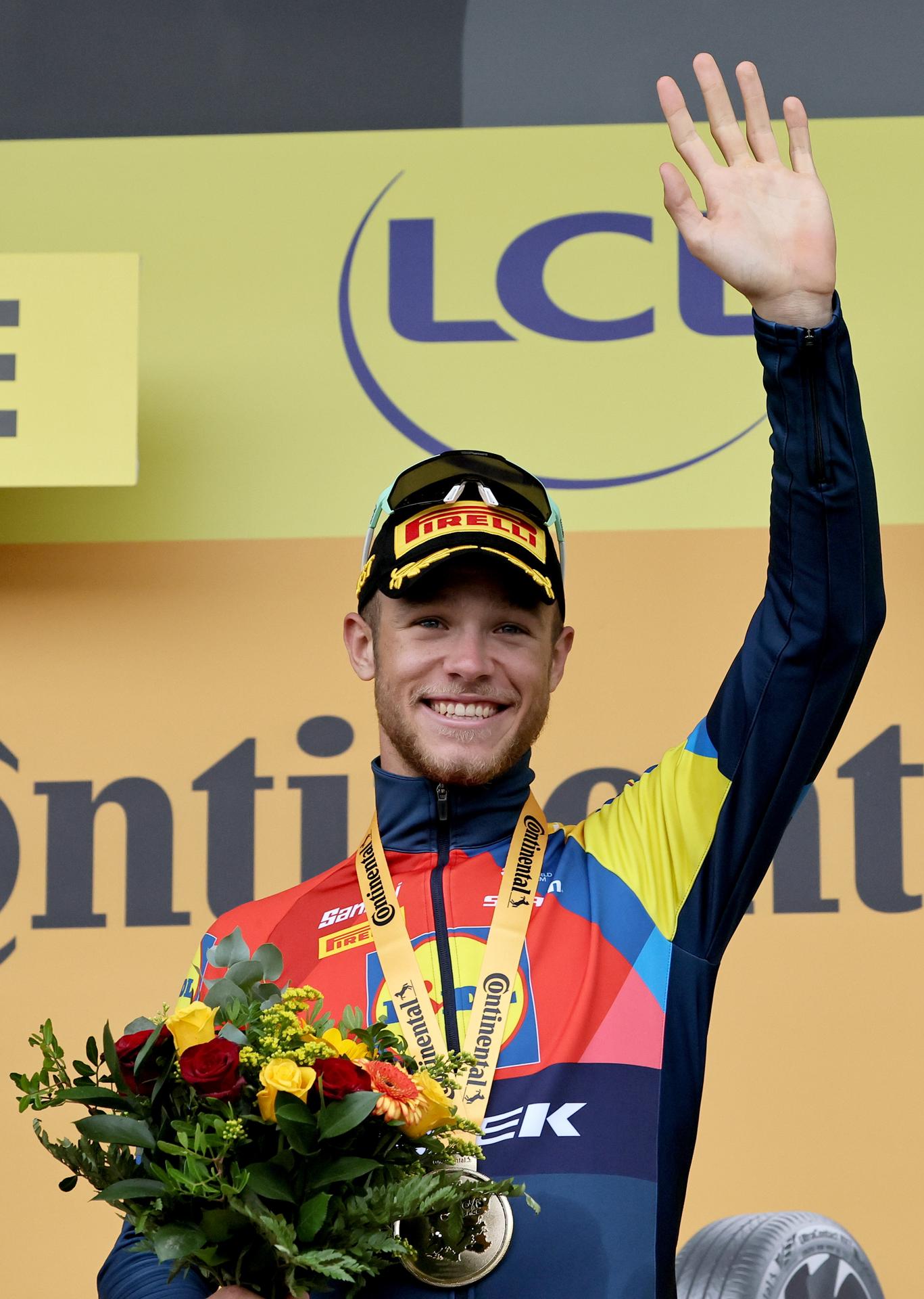El líder de la clasificación por puntos, el italiano Jonathan Milan (Lidl Trek) (c) celebra en el podio su victoria de este miércoles, en el esprint de la 17ª etapa del Tour de Francia. EFE/CHRISTOPHE PETIT TESSON
