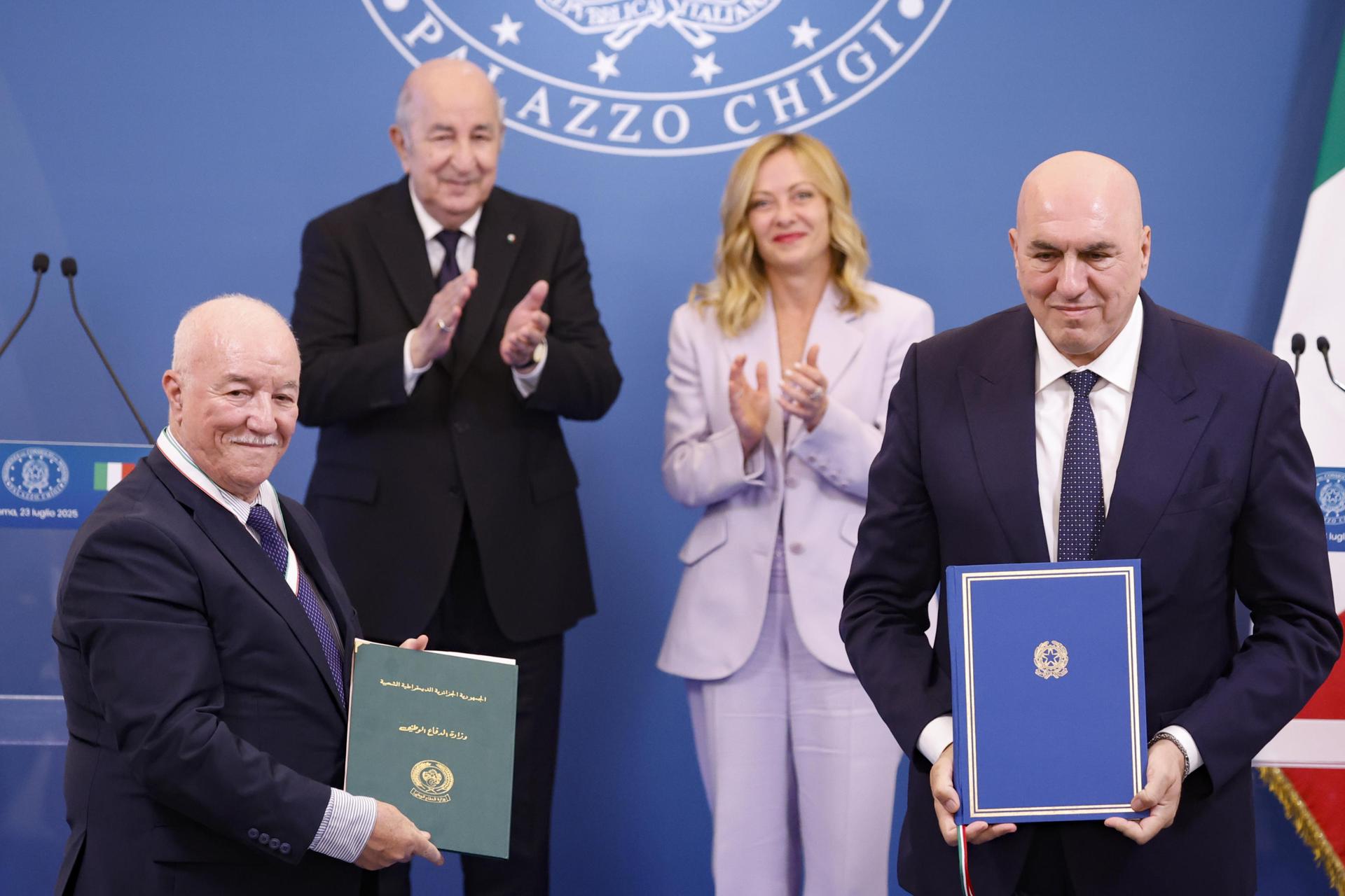 La primera ministra italiana, Giorgia Meloni (der., atrás), y el presidente argelino, Abdelmadjid Tebboune (izq., atrás), observan mientras el ministro de Defensa italiano, Guido Crosetto (der., delante), intercambia documentos con el secretario general del Ministerio de Defensa Nacional de Argelia, Mohamed Salah Benbicha (izq., delante), durante una ceremonia de firma como parte de la cumbre intergubernamental Italia-Argelia en Roma, Italia, el 23 de julio de 2025.EFE/EPA/FABIO FRUSTACI