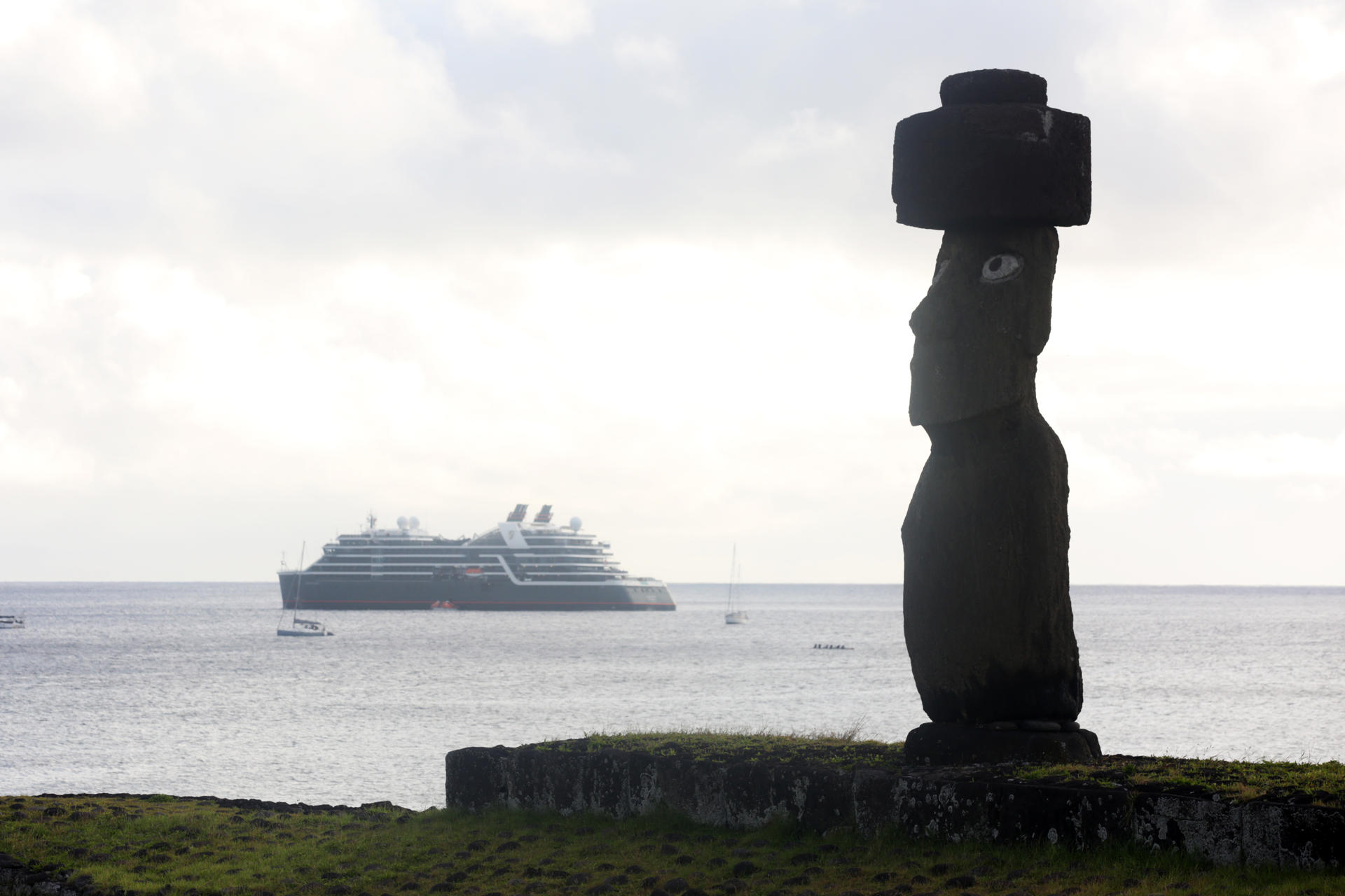 Fotografía de archivo de un crucero turístico que pasa frente a un moai del "Ahu Tahai" (tumba de los antepasados), Ubicado en Hanga Roa, Isla de Pascua (Chile). EFE/ Elvis González