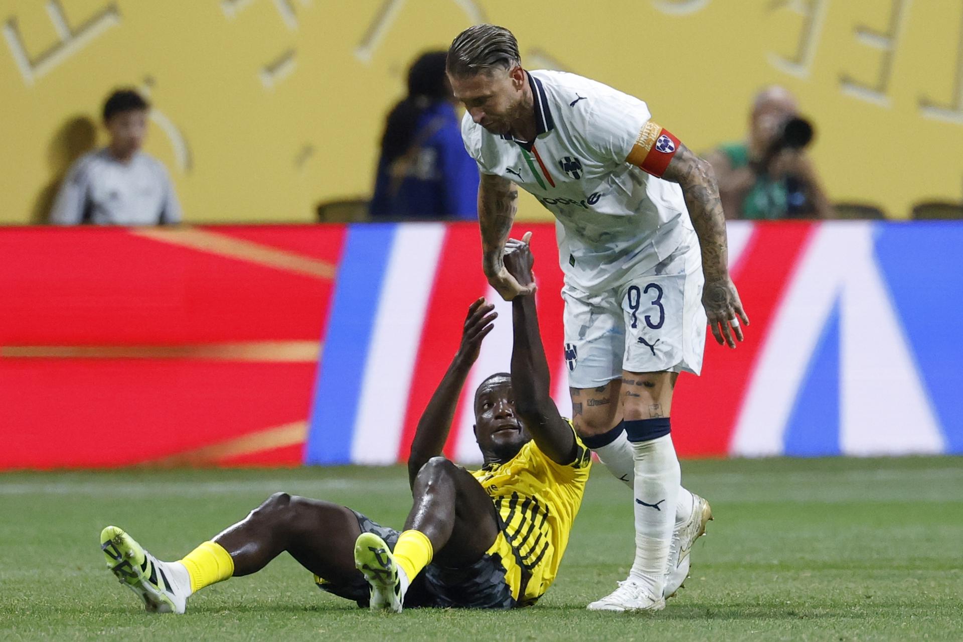 Serhou Guirassy, del Borussia Dortmund, es ayudado por el español Sergio Ramos, del Monterrey. EFE/EPA/ERIK S. LESSER
