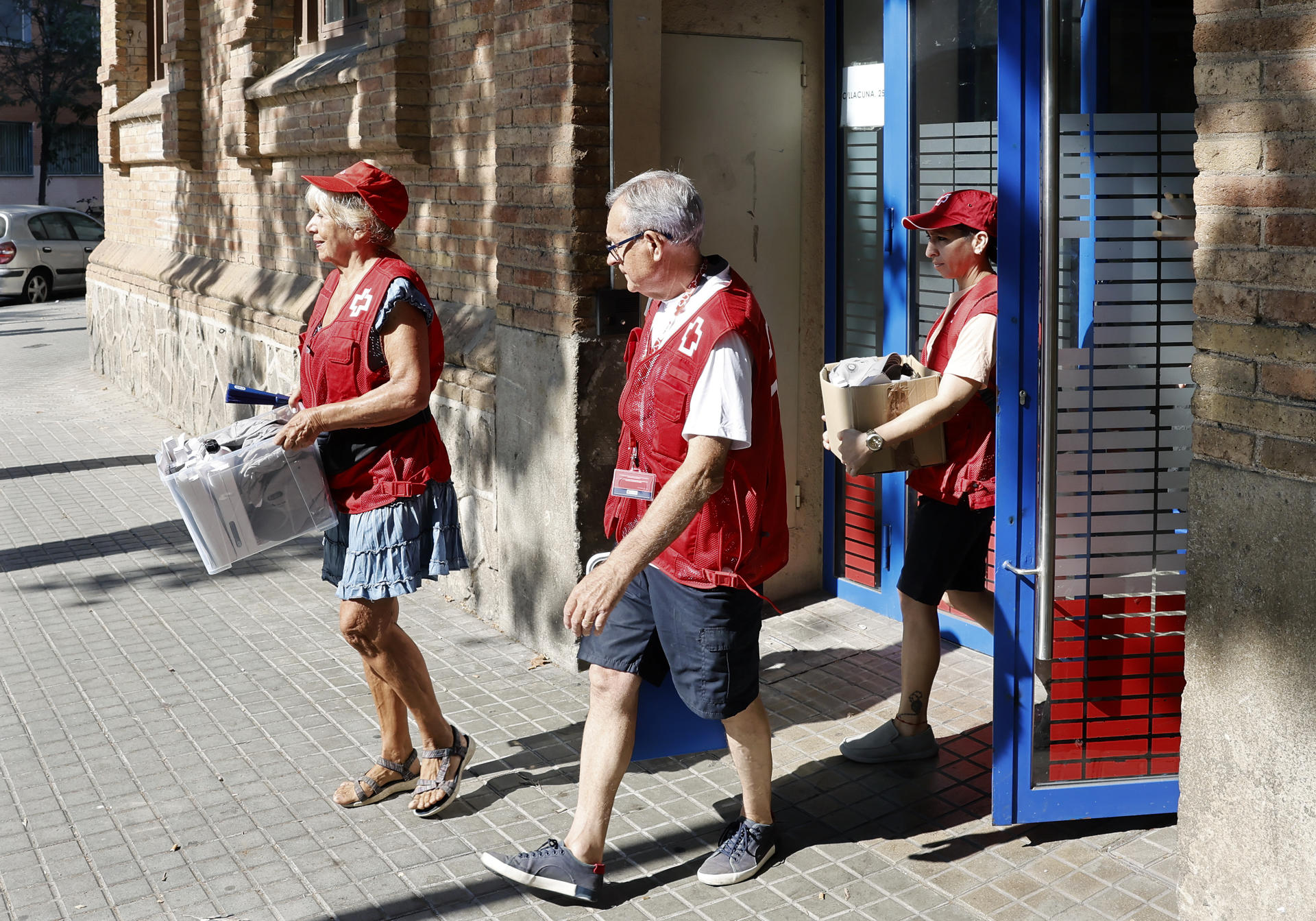 Personal del Centro de urgencias y emergencias sociales de Barcelona (CUESB) que ha activado el dispositivo previsto en la capital catalana ante la ola de calor sale a la calle para dar información de los espacios refugio de la ciudad y entregar agua, cantimploras, gorras a personas sin hogar en situación vulnerable. EFE/Andreu Dalmau