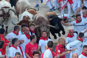 Varios corredores caen al paso de uno de los toros de la ganadería Álvaro Núñez durante el tercer encierro de los Sanfermines 2025 este miércoles en Pamplona. EFE/ Villar López