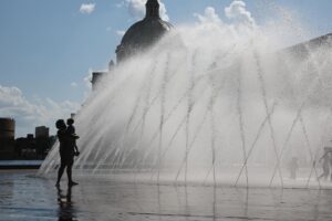 Fotografía de archivo de una mujer y su hijo quienes disfrutan de los chorros de una fuente, en Estados Unidos, que ha registrado altas tempraturas. EFE/ CJ Gunther