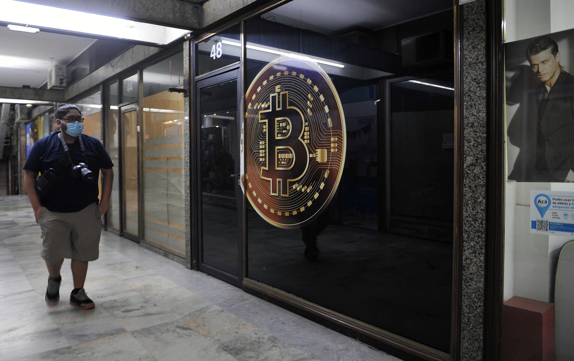 Fotografía de archivo de un hombre caminando frente a una tienda de criptomonedas el 22 de febrero de 2022, en la zona bancaria de Buenos Aires (Argentina). EFE/ Enrique García Medina