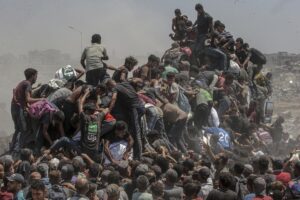 Palestinos intentan conseguir sacos de harina de un camión de ayuda cerca de un punto de distribución de alimentos en Zikim, al norte de la Franja de Gaza, este domingo. EFE/MOHAMMED SABER
