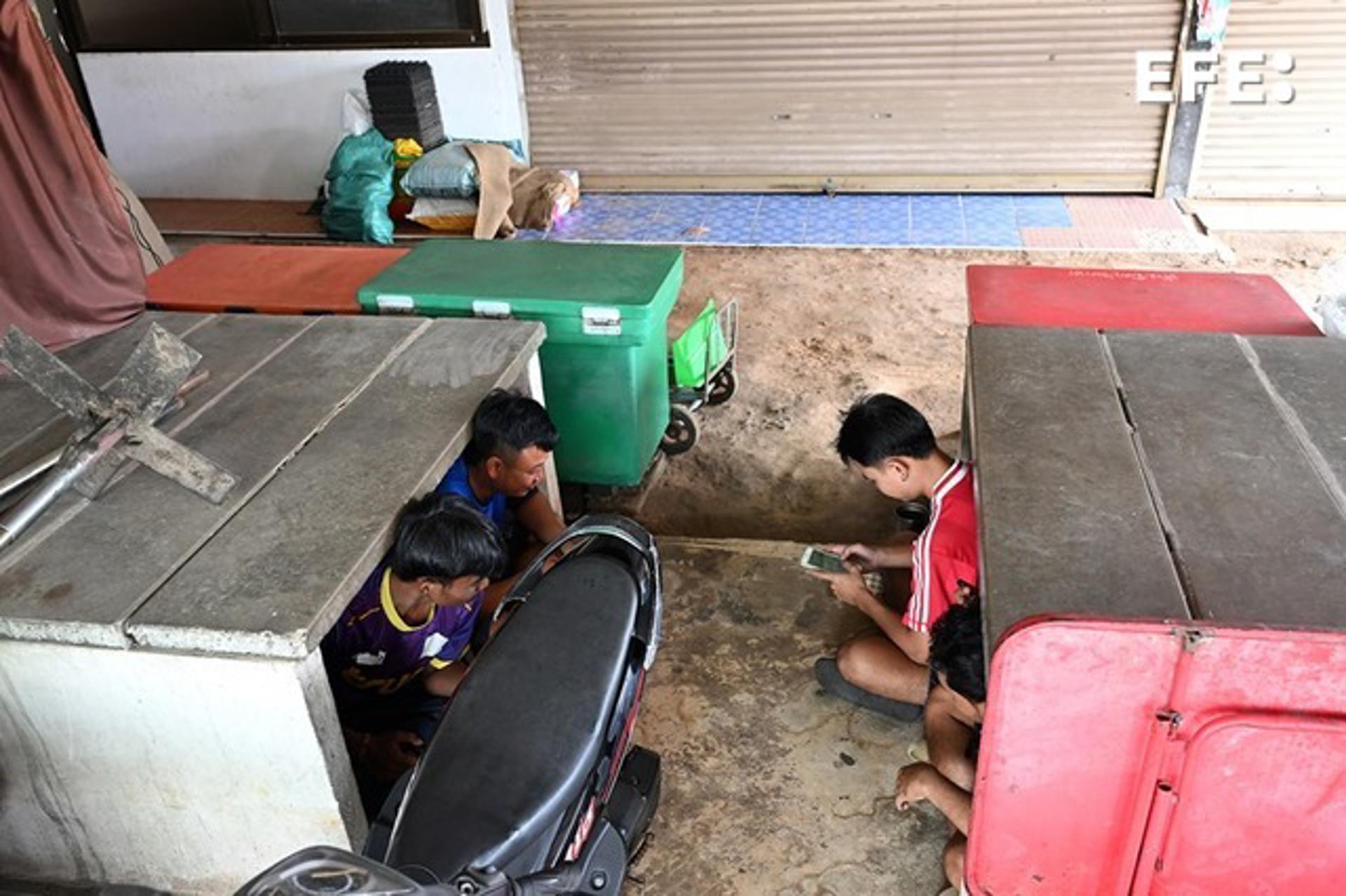 KAB CHOENG (Tailandia), 26/07/2025.- Aldeanos se refugian bajo una plataforma de hormigón cerca del mercado de Chong Chom, en medio de enfrentamientos en la disputada frontera entre Tailandia y Camboya. EFE/EPA/KAIKUNGWON DUANJUMROON
