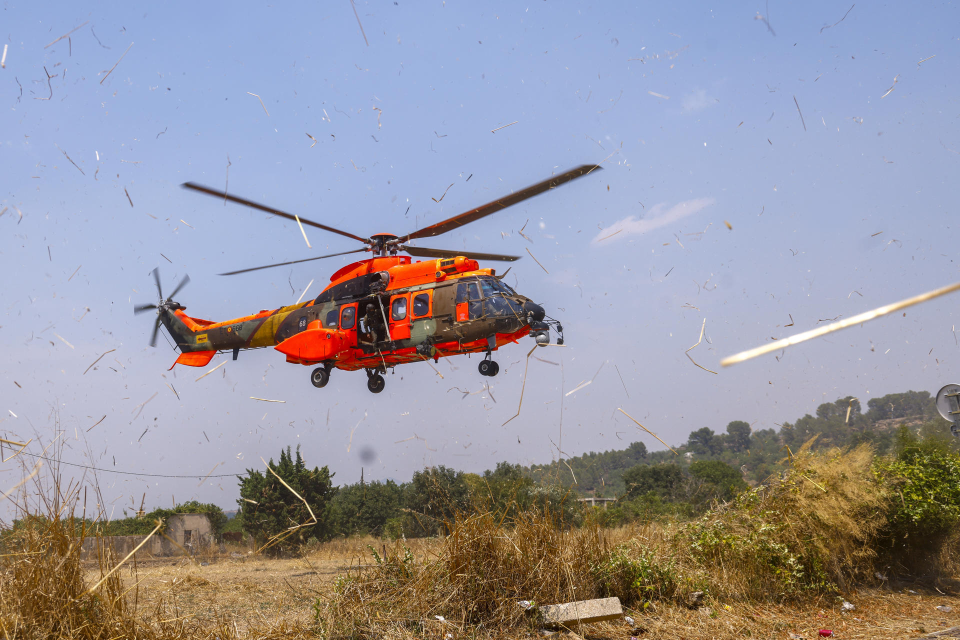 Un helicóptero de la Unidad Militar de Emergencias (UME), que ya está trabajando bajo la dirección de los Bomberos en la extinción del incendio forestal de alta intensidad iniciado ayer en Paüls (Tarragona) llega al centro de mando de los Bomberos en Tortosa (Tarragona). EFE/ Quique García