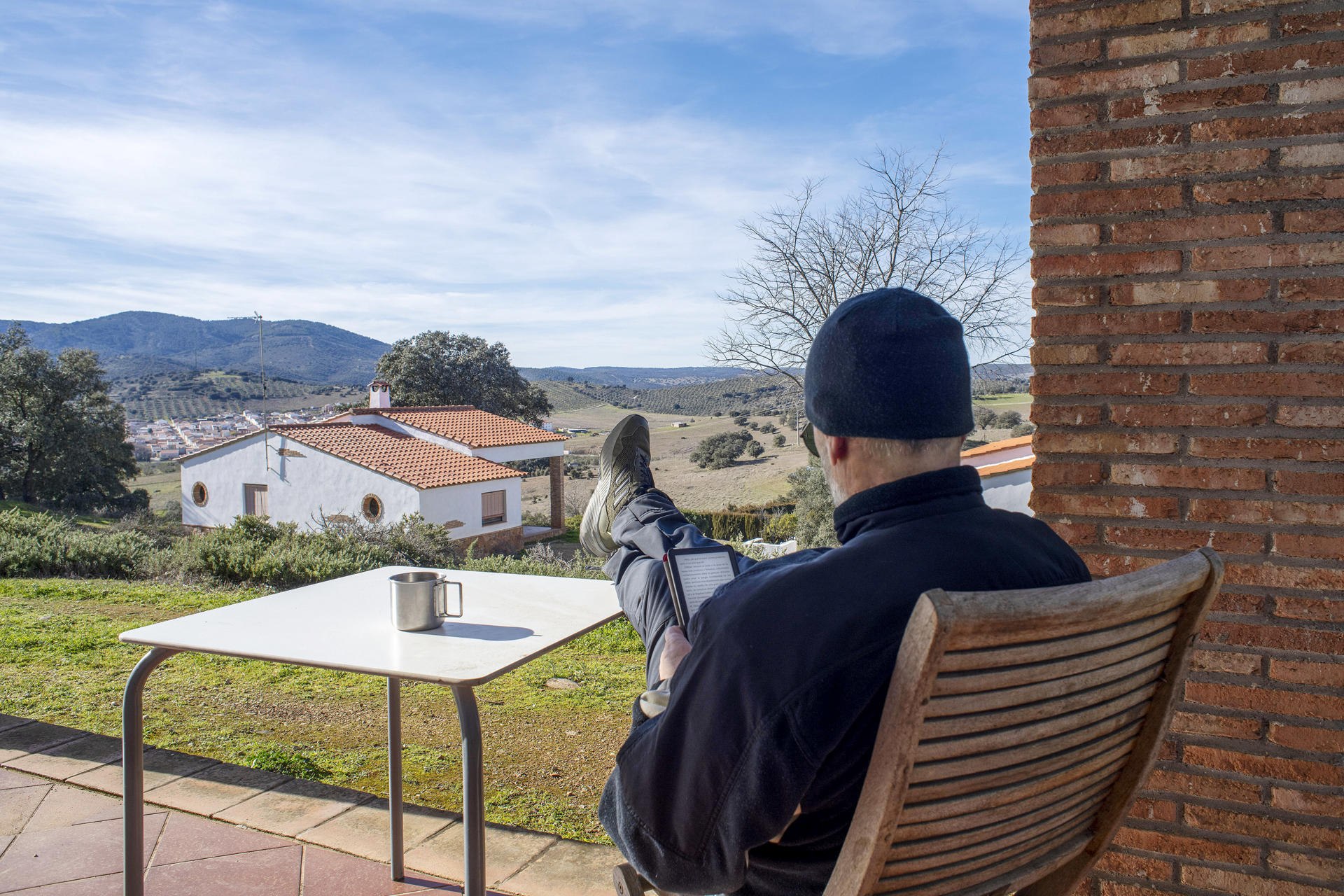 Un usuario descansa en el porche de una de las casas rurales La Aldeílla de Aldeaquemada (Jaén). EFE/ José Manuel Pedrosa