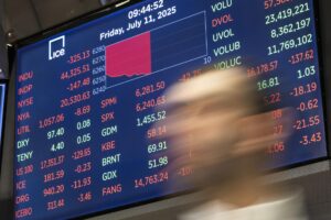 Foto de archivo de una persona pasando frente a una pantalla que muestra el promedio industrial Dow Jones durante la campana de apertura en el piso de la Bolsa de Valores de Nueva York. EFE/EPA/JUSTIN LANE