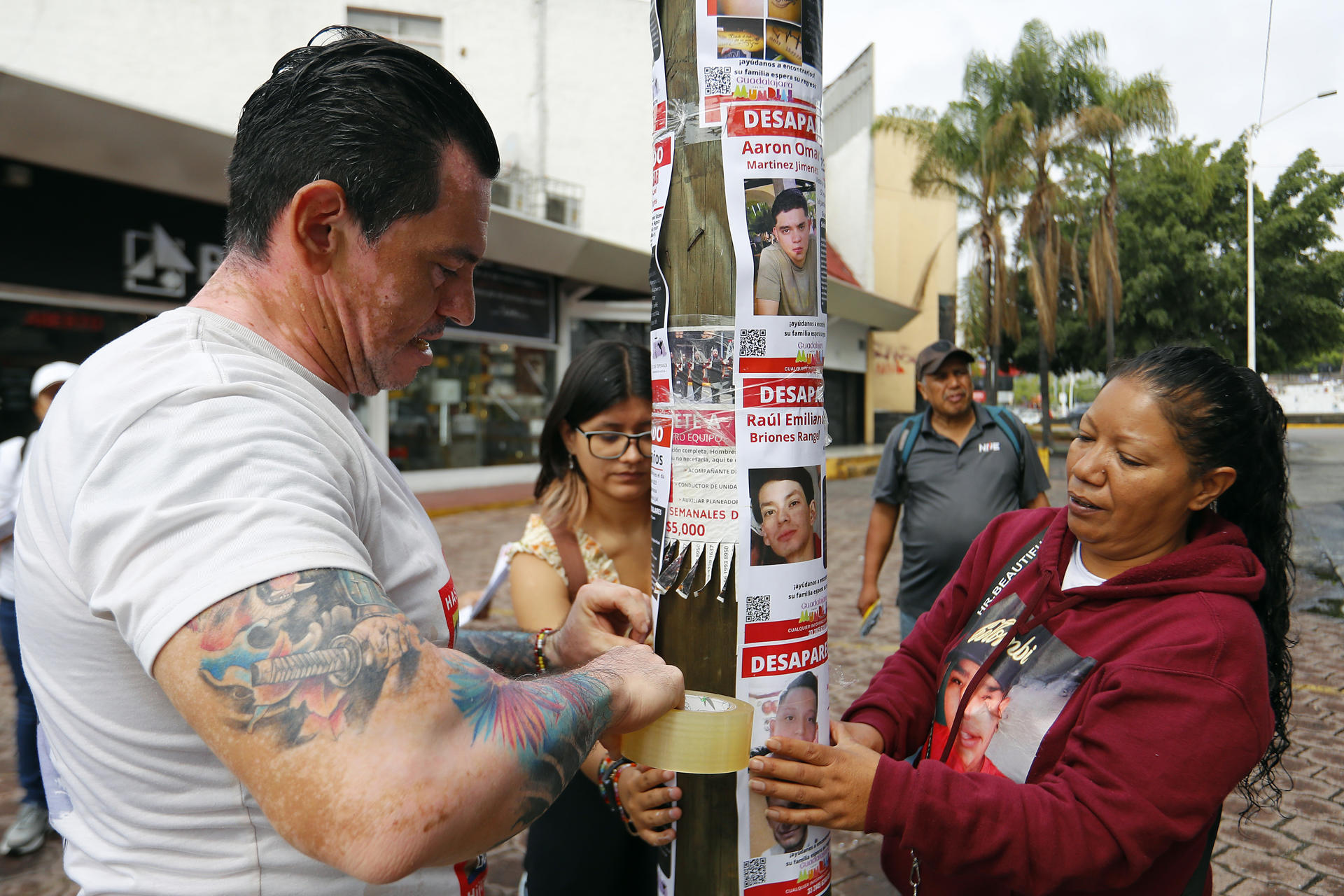 Integrantes de colectivos de búsqueda pegan carteles de personas desaparecidas este sábado, en Guadalajara (México). EFE/ Francisco Guasco