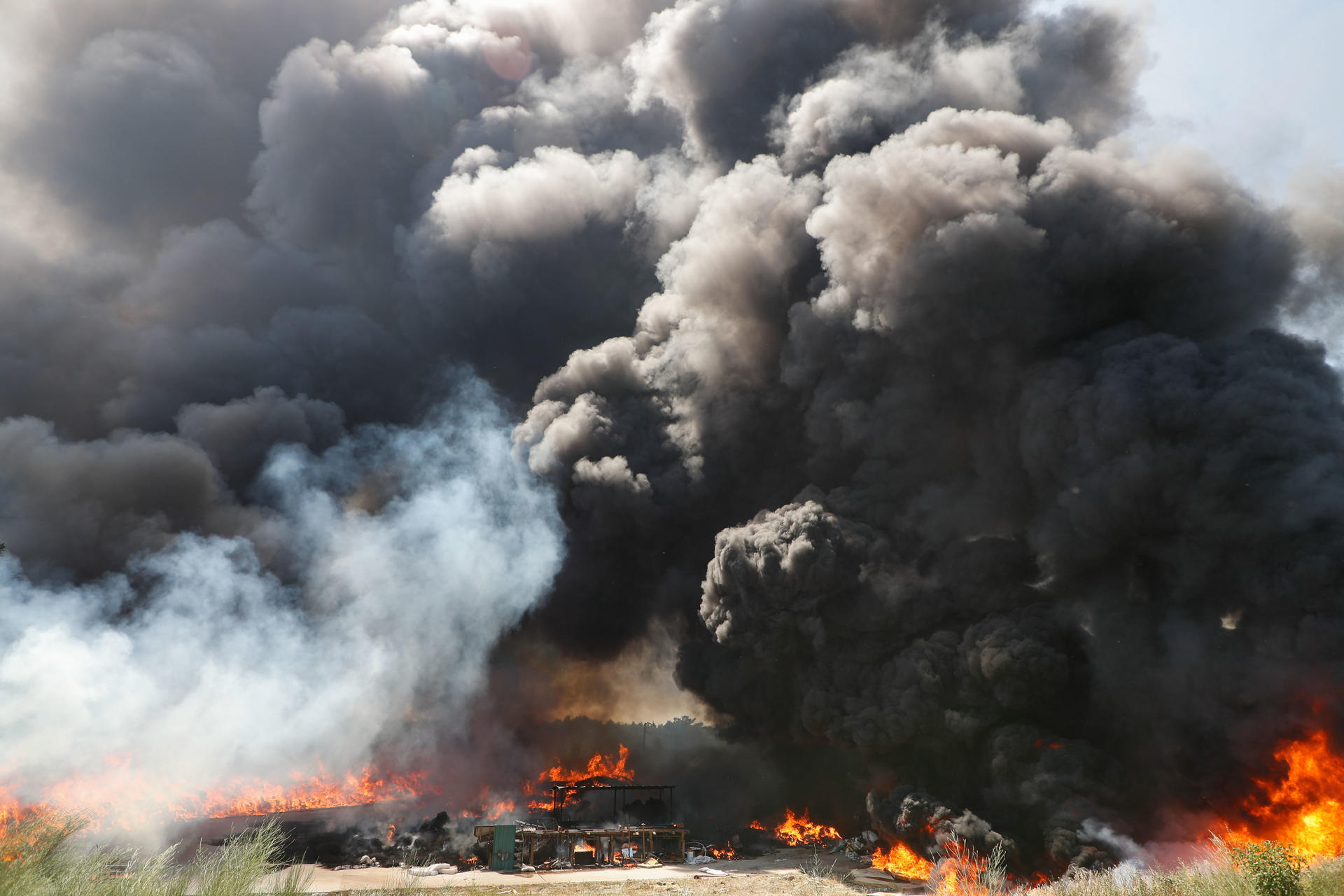 Un incendio industrial que afecta a la nave de la empresa Espomasa, ubicada en la parroquia de Marzá, Palas de Rei, Lugo, ha levantado una humareda que se ve a kilómetros de distancia. EFE/Eliseo Trigo