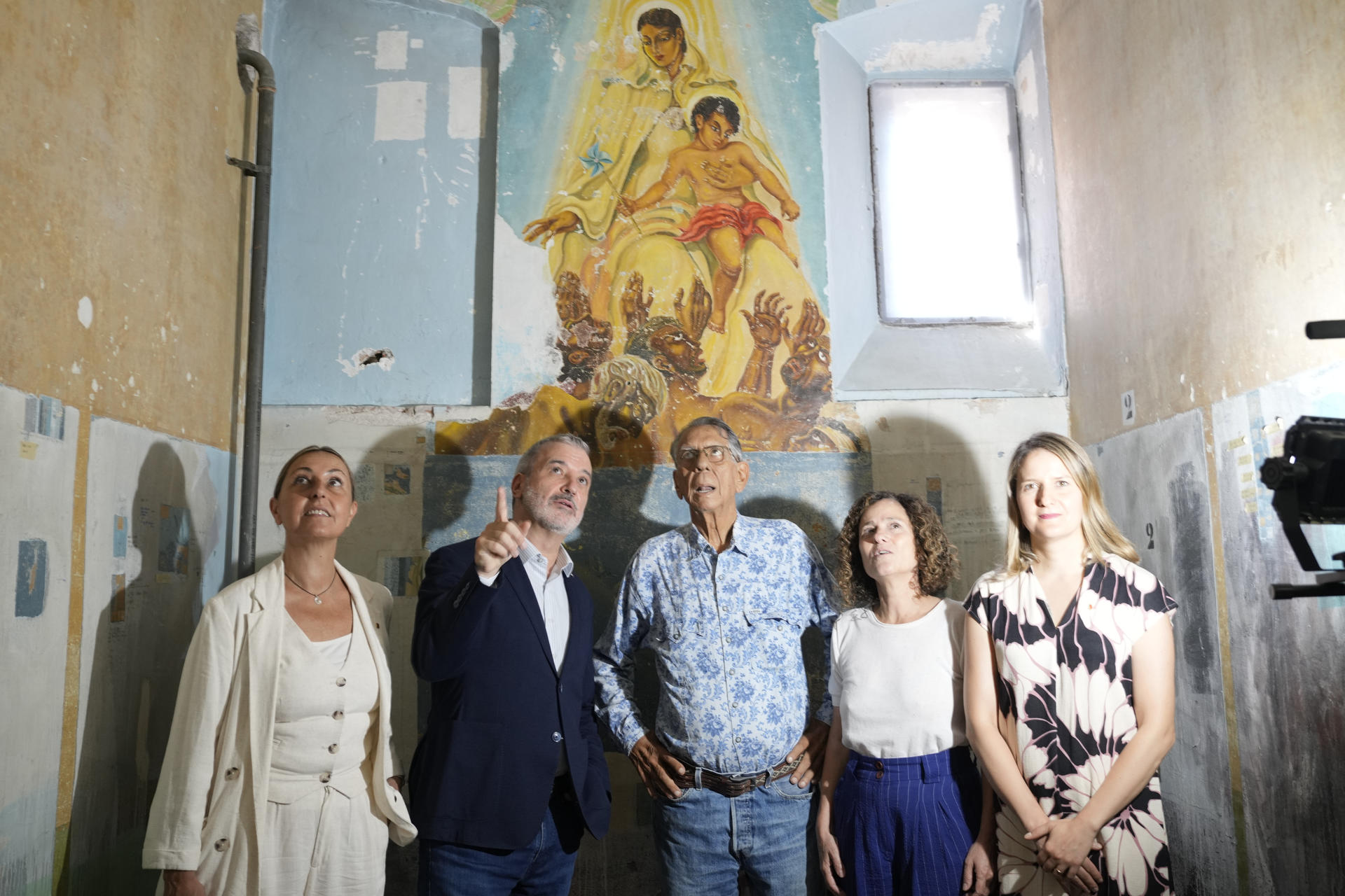 El alcalde de Barcelona, Jaume Collboni (2i), acompañado de la consellera de Cultura, Sonia Hernandez (d), la consellera de Igualdad y Feminismo, Eva Menor (i), y Gabriel Gómez, hijo de Helios Gómez, durante la presentación hoy de los resultados del proceso de conservación y restauración de las pinturas murales que el artista y preso político Helios Gómez realizó en los años 50 del pasado siglo en la antigua cárcel Modelo, en una celda que pasó a denominarse la 'Capilla Gitana'. EFE/Alejandro García