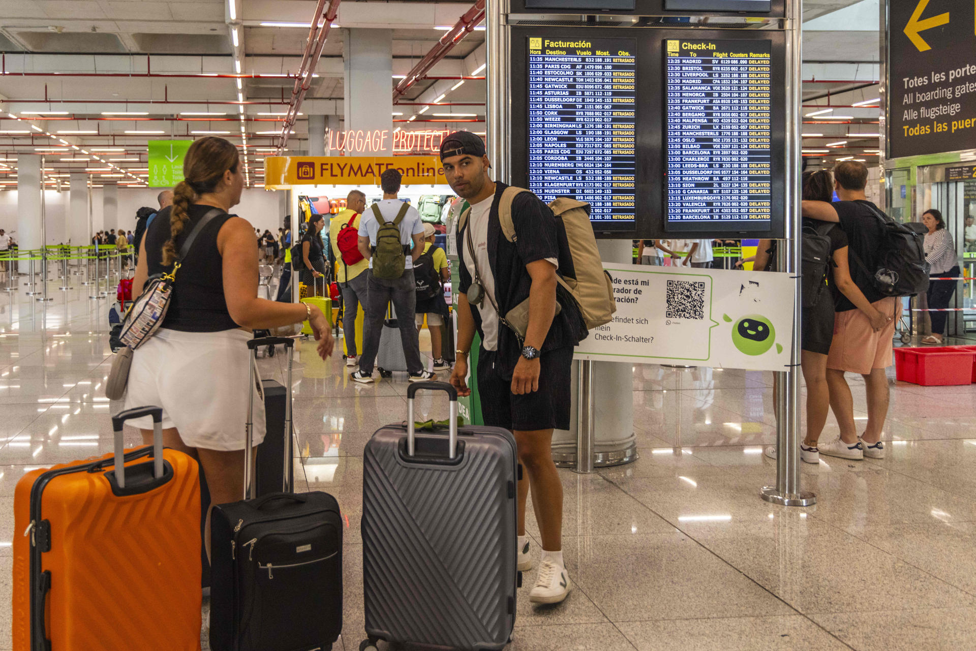 Varias personas esperan este jueves en el Aeropuerto de Palma. La intensa tormenta que ha afectado a primera hora de la mañana de este jueves al aeropuerto de Palma ha ocasionado retrasos generalizados en las llegadas y salidas de aviones y ha provocado goteras en las zonas de tránsito de pasajeros. EFE/ Cati Cladera