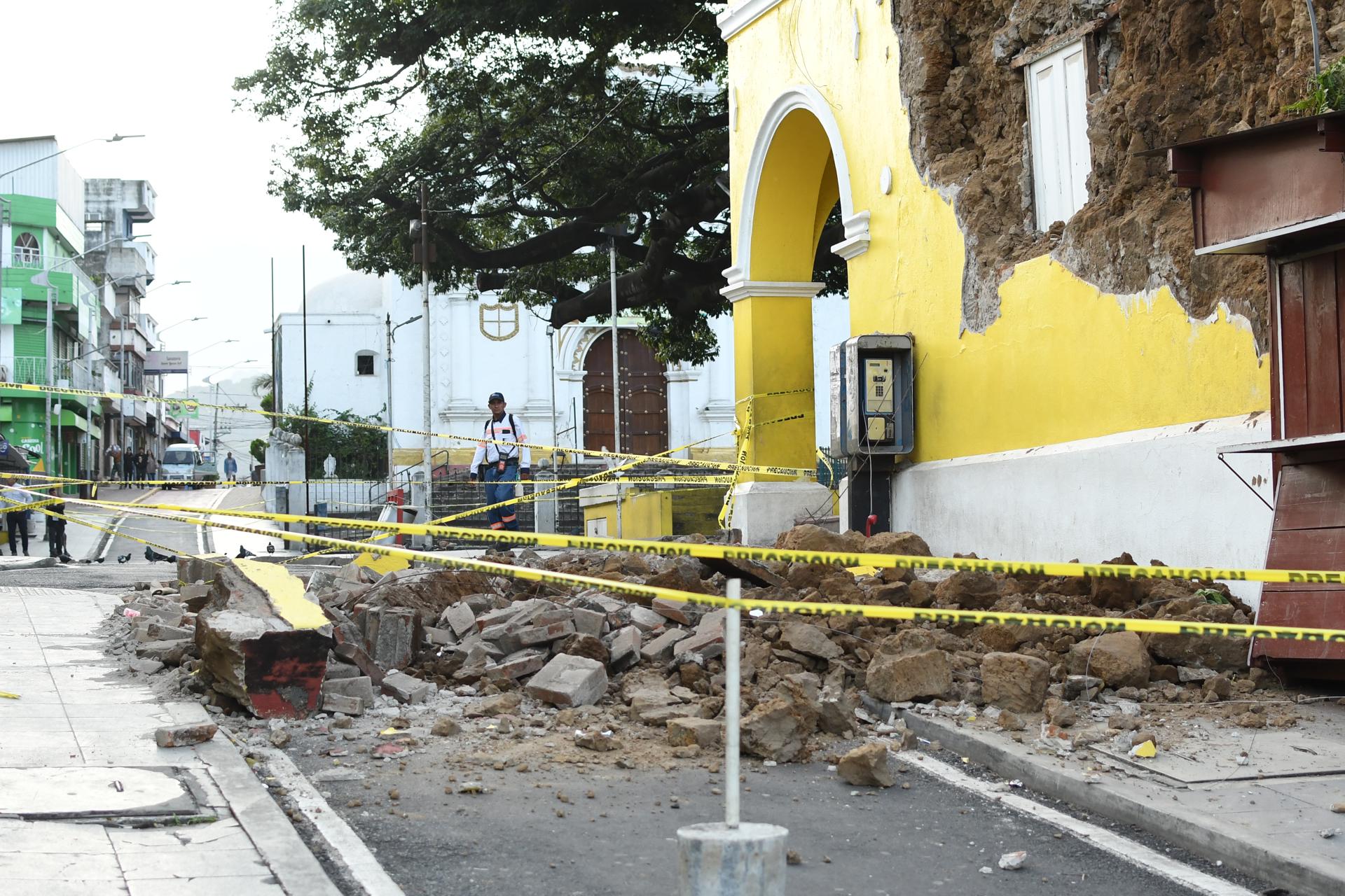 Una persona camina este miércoles cerca de los escombros ocasionados tras los fuertes temblores, en Palín (Guatemala). EFE/Alex Cruz