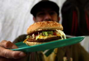 Un hombre muestra una hamburguesa, en una fotografía de archivo. EFE/ Mario Guzmán