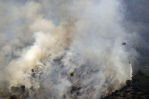 Un helicóptero trabaja en la tareas de extinción del incendio forestal de Paüls (Tarragona. EFE/ Quique García