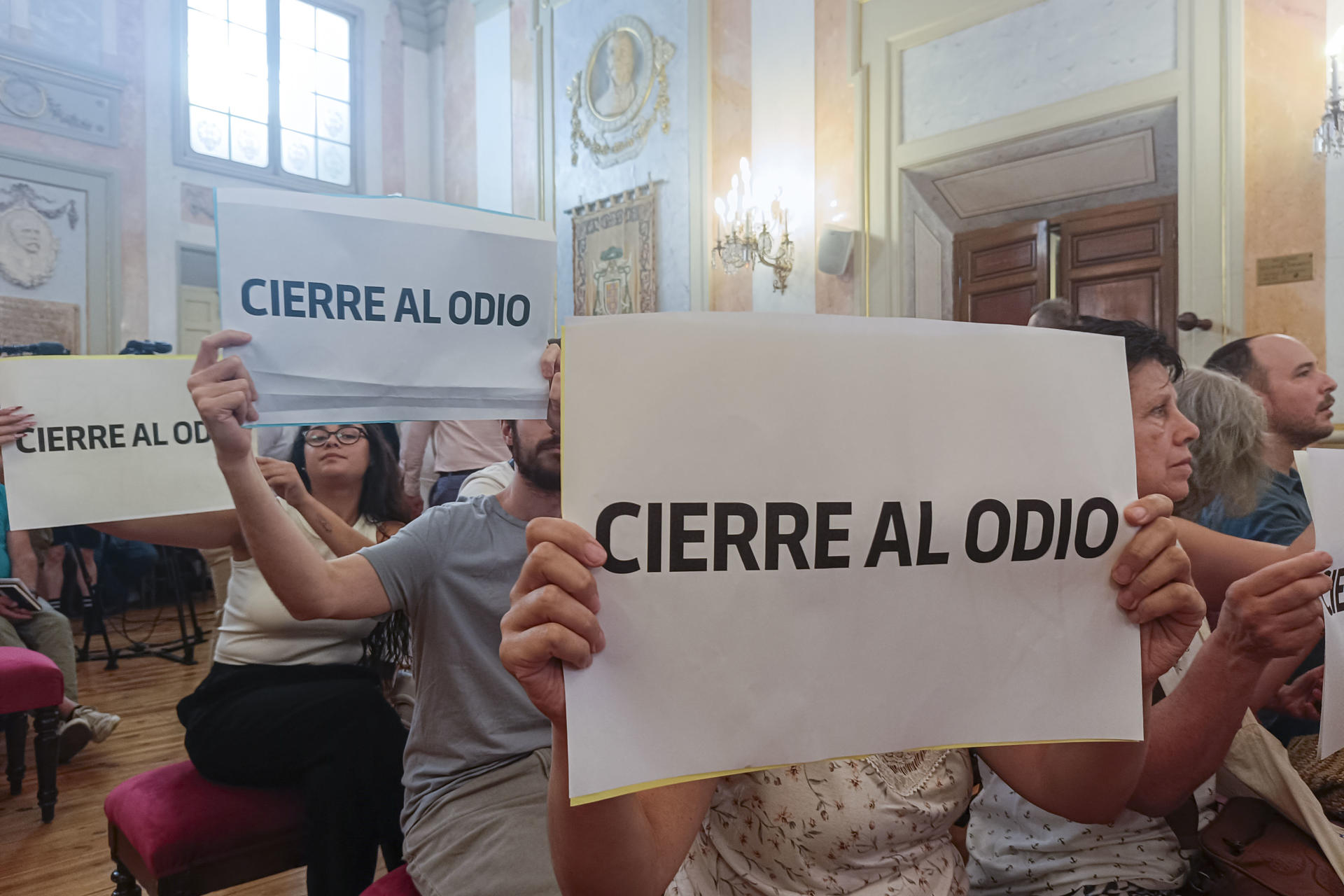 Vecinos de Alcalá de Henares muestran su rechazo a la petición de cierre del centro de Acogida, Emergencia y Derivación (CAED), y portan pancartas con el lema 'Cierre al Odio', después de que el pleno del Ayuntamiento del municipio madrileño haya aprobado este martes exigir al Gobierno central el cierre del CAED, iniciativa que ha salido adelante con los votos de PP y Vox. EFE/ Guillermo Martínez