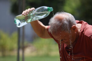 Un hombre se refresca con agua de una botella, en una imagen de archivo. EFE/Salas
