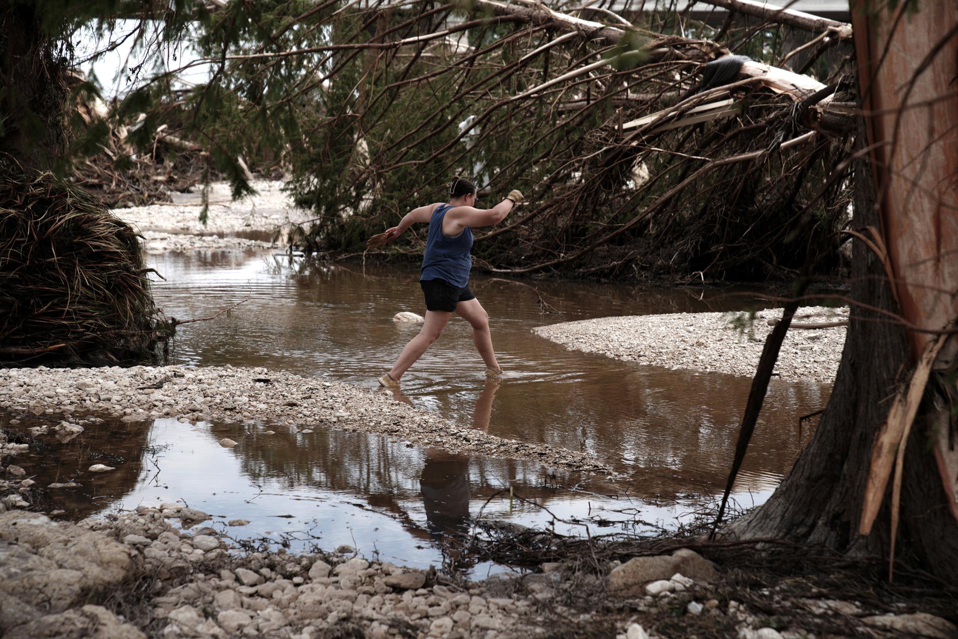 Una mujer cruza una sección del río Guadalupe, en Ingram, Texas, el 7 de julio de 2025. EFE/DUSTIN SAFRANEK