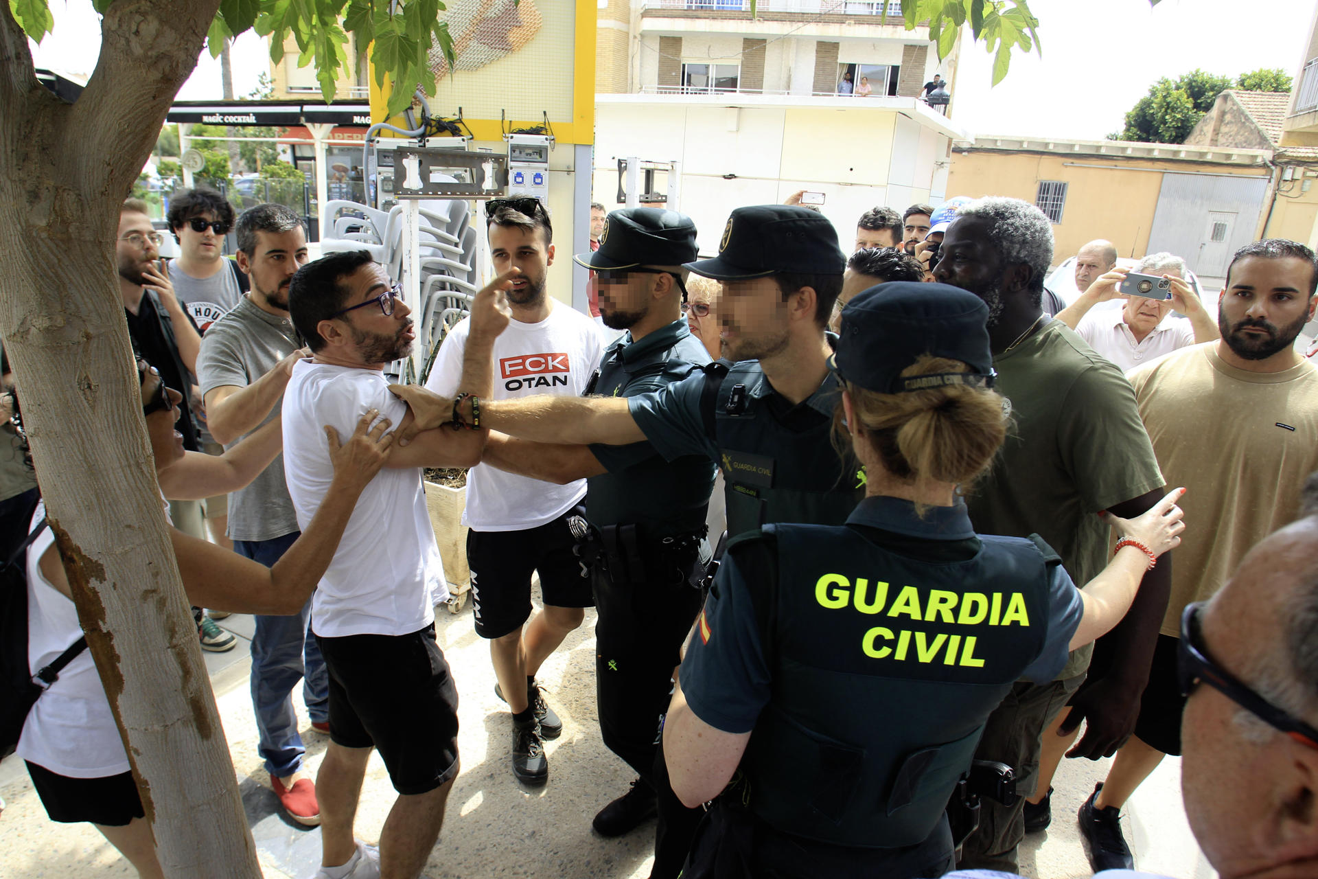 Simpatizantes de Podemos y el periodista de Libertad Periodista Digital, Bertrand Ndongo (2d), durante la visita que la secretaria general de Podemos, Ione Belarra, ha realizado a Torre Pacheco, junto a otros miembros de su partido, para mostrar su apoyo a los vecinos de la localidad tras los recientes episodios de violencia racista, este martes. EFE/ Morell