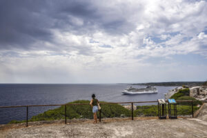 Turistas observan este miércoles la llegada de nubes de lluvia desde la Fortaleza de Isabel II en La Mola, Menorca. EFE/David Arquimbau Sintes