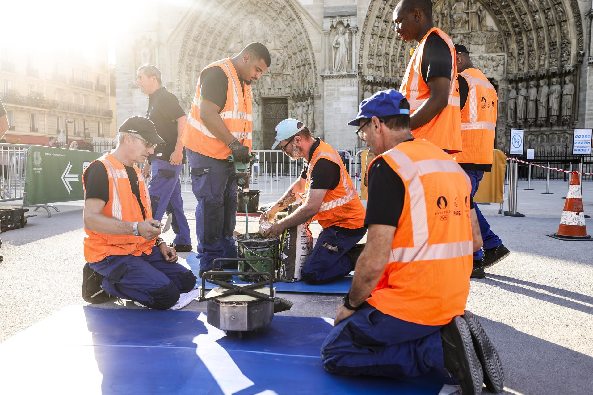 Los trabajadores instalan un nuevo marcador del kilómetro 0 en los aledaños de la catedral de Notre Dame de París, el 1 de julio de 2025. EFE/EPA/TERESA SUAREZ

