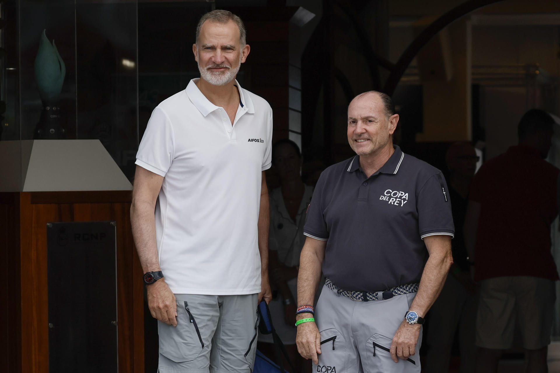 El rey Felipe VI llega al Real Club Náutico de Palma, donde ha sido recibido por el presidente de la entidad, Rafael Gil (d), para participar a bordo del AIfos en la primera regata de la 43 Copa del Rey Mapfre de vela. EFE/Ballesteros

