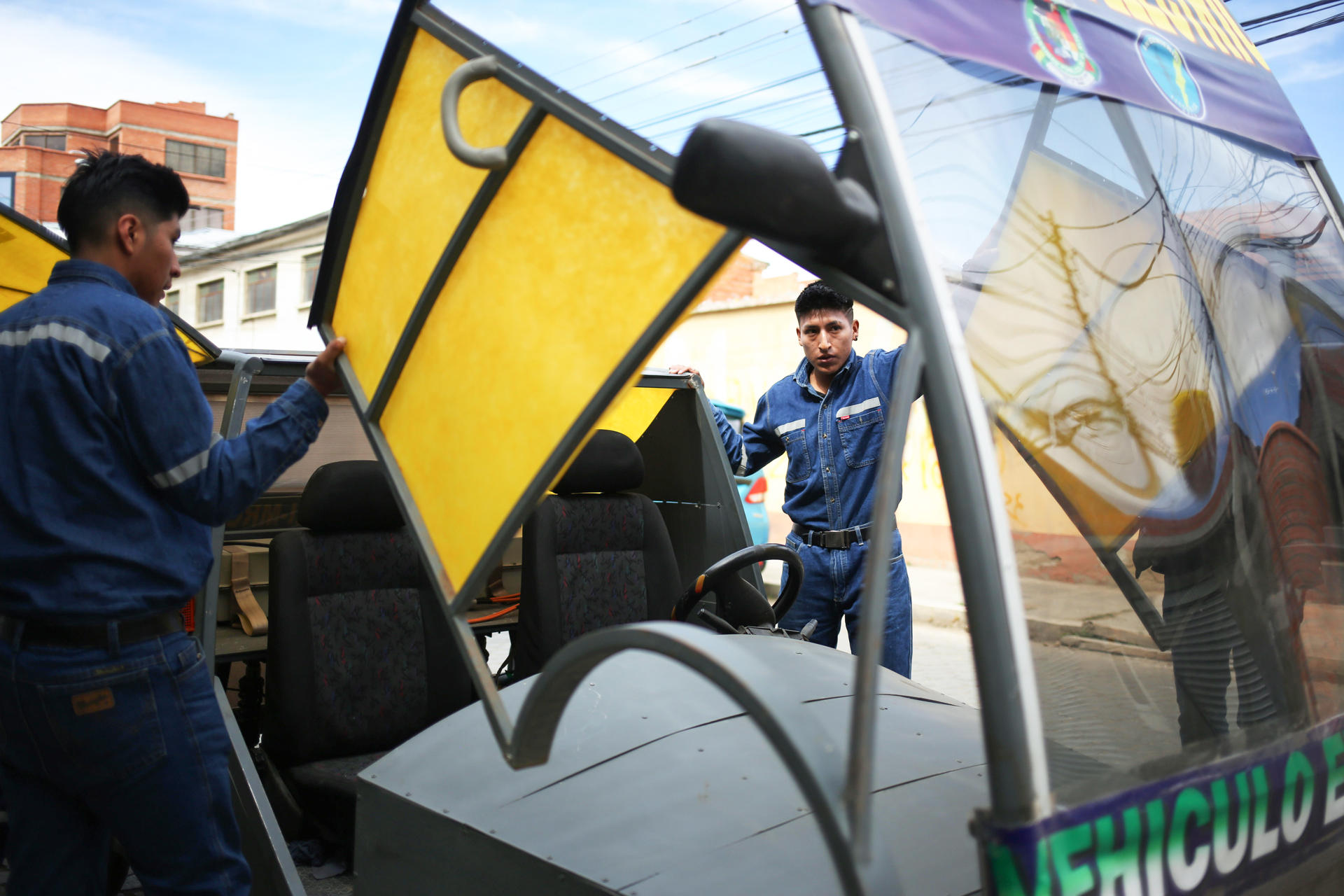 Fotografía del 3 de julio de 2025 de estudiantes revisando el auto eléctrico 'Katari MRC5' en El Alto (Bolivia). EFE/ Luis Gandarillas