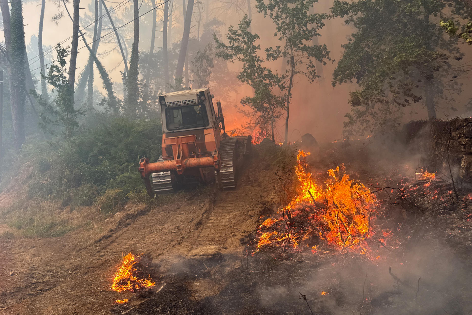 Labores de extinción este miércoles del incendio forestal declarado en las inmediaciones de A Cañiza. EFE/ Sxenick
