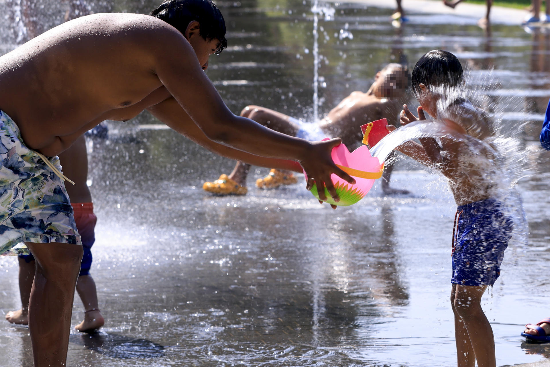 Un grupo de niños se refresca en los chorros de agua de Madrid Río este martes. EFE/ Pablo R. Seco