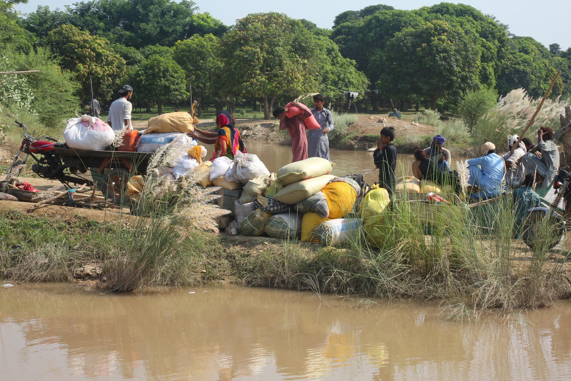 La gente acarrea sus pertenencias huyendo de las inundaciones ocasionadas tras el desbordamiento del río Sutlej, en la provincia de Punjab, Pakistán. EFE/EPA/MANSOOR ABBAS