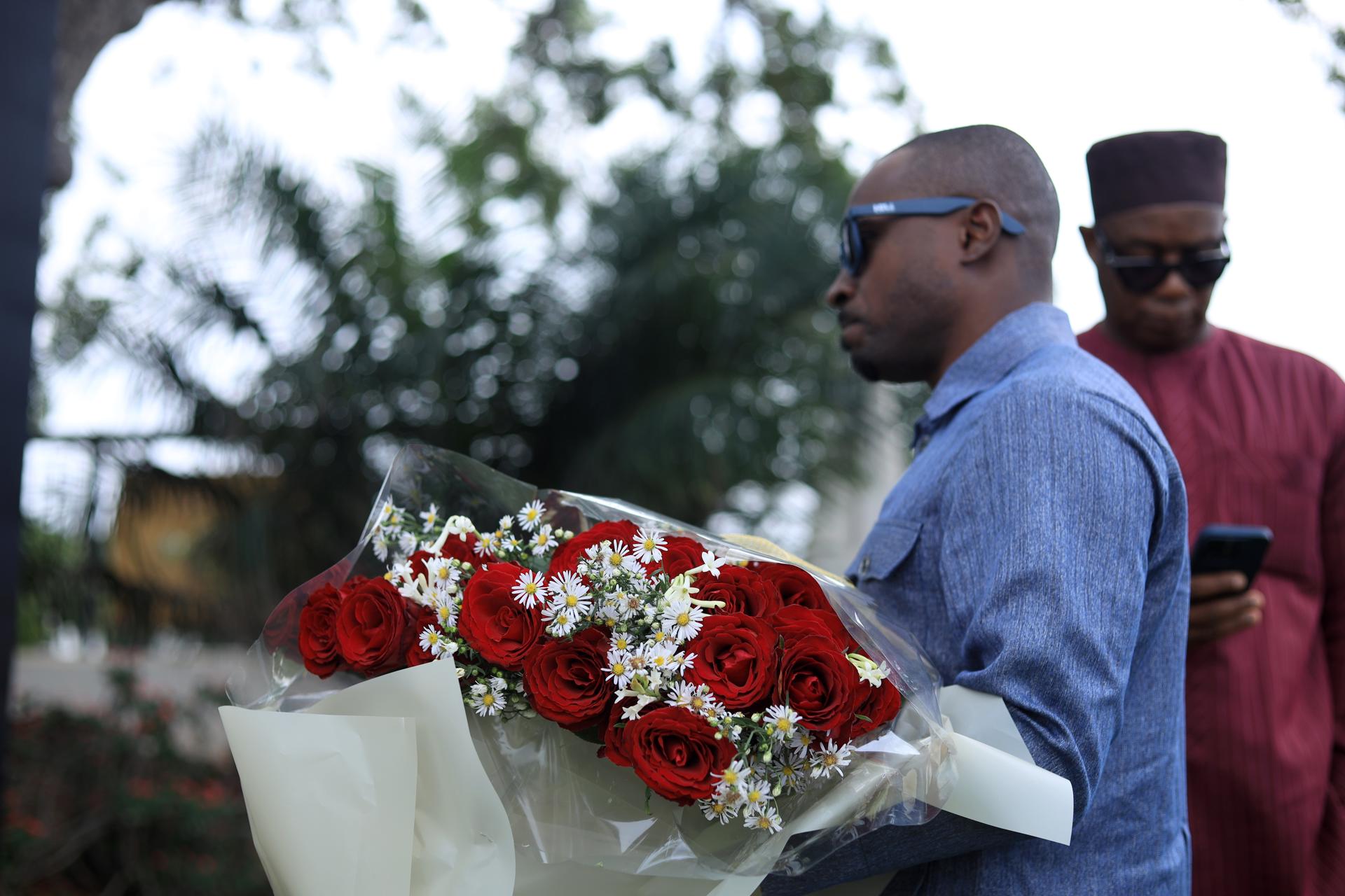 Dolientes colocan flores y rinden homenaje a las víctimas de un accidente de helicóptero durante una vigilia frente a la Casa del Jubileo en Accra, Ghana. EFE/EPA/FRANK KPORFOR
