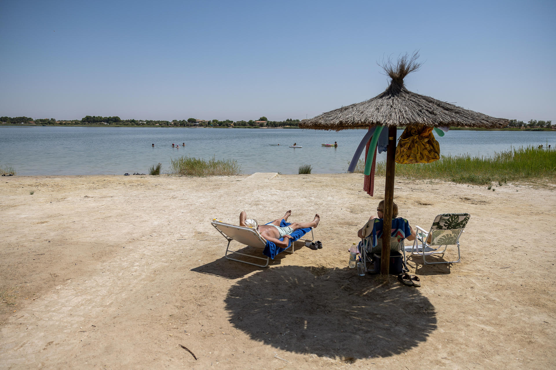 Vecinos de Villafranca de los Caballeros combaten el calor en la Laguna Grande este lunes. EFE/Ismael Herrero