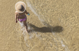 Una mujer pasea por la orilla de la playa de La Concha de San Sebastián este jueves, donde se esperan temperaturas superiores a 30ºC. EFE/Javier Etxezarreta