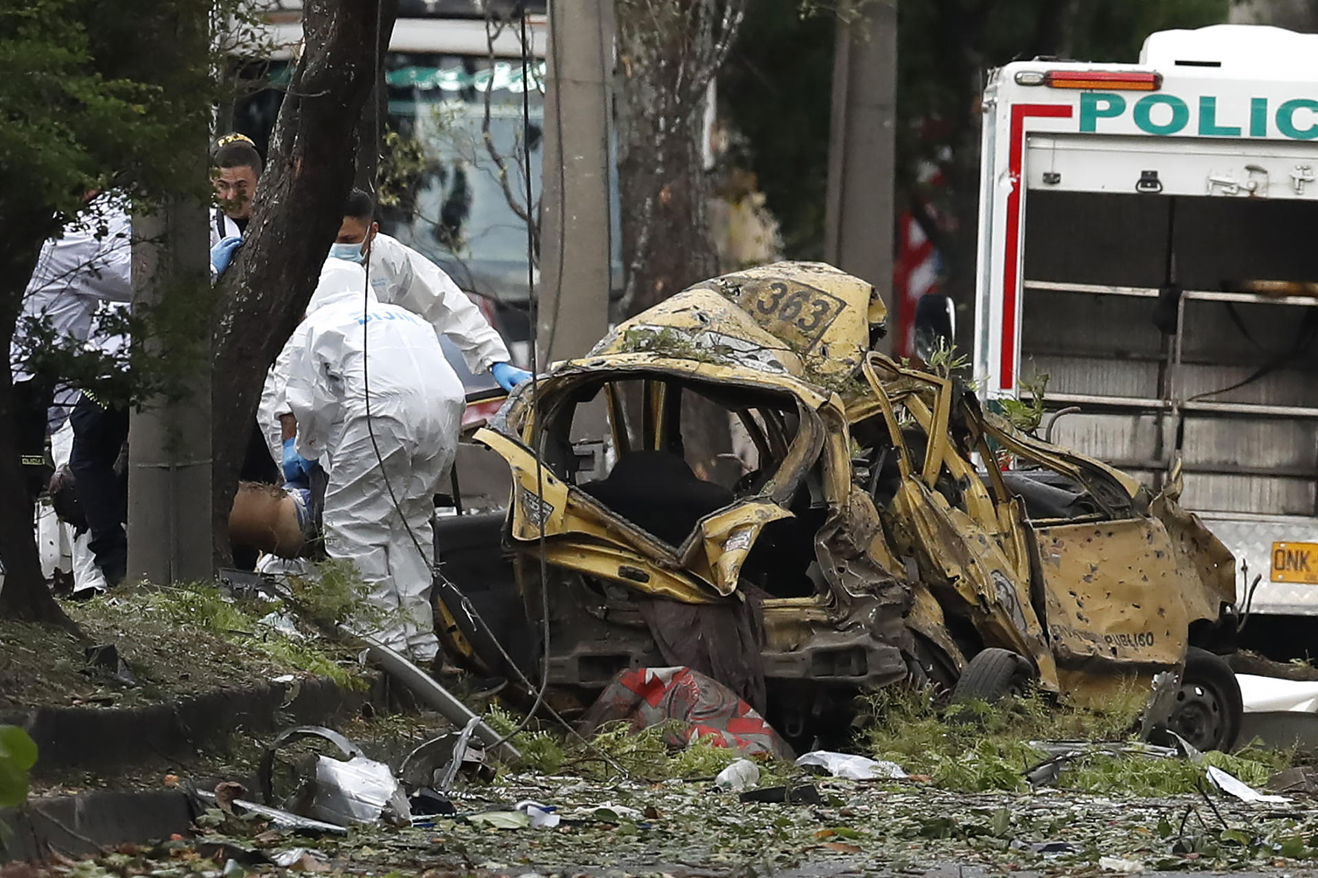 Integrantes de la Dirección de Investigación Criminal e Interpol (DIJIN) inspeccionan un vehículo afectado tras una explosión en inmediaciones de la Escuela Militar de Aviación Marco Fidel Suárez este jueves, en Cali (Colombia). EFE/ Ernesto Guzmán Jr
