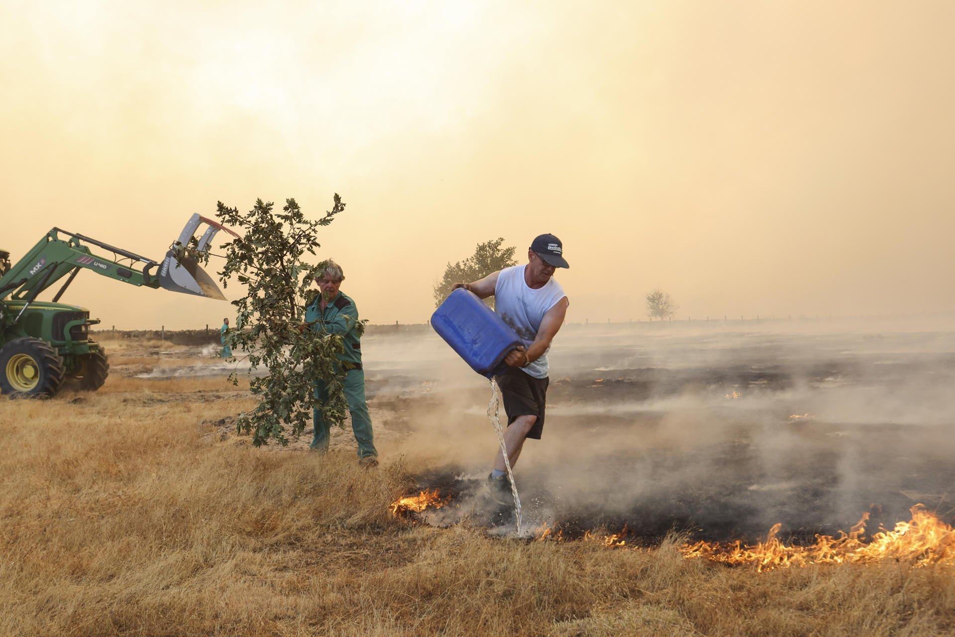 Dos voluntarios trabajan en la extinción del incendio forestal este viernes, en las proximidades de Cipérez (Salamanca). EFE/JM GARCIA
