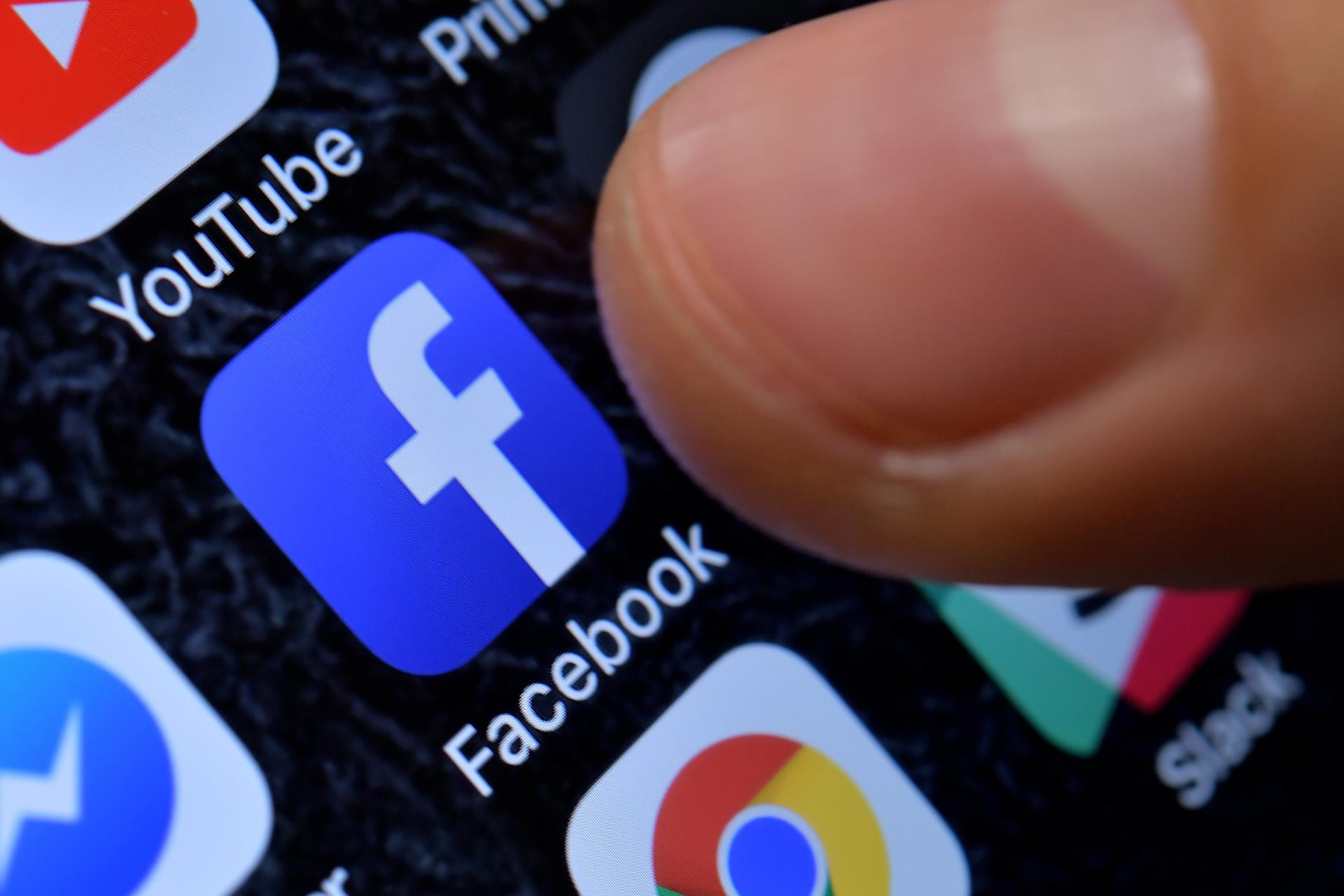 Fotografía de archivo de una persona señalando la aplicación de Facebook. EFE/ Sascha Steinbach
