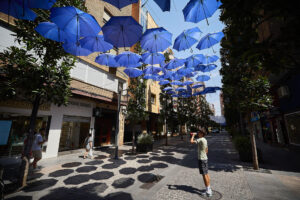 Un entramado de paraguas da sombra a un paseo peatonal este miércoles en la localidad toledana de Talavera de la Reina, que marcó ayer la temperatura máxima del país, 42,7 grados a las 18:20 horas. EFE/Manu Reino